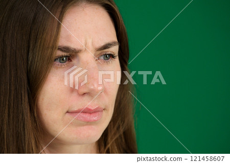 Thoughtful Asian woman keeps hand on chin looks pensively above dressed in casual blue jumper poses against brown background blank copy space for your advertising content thinks about future 121458607