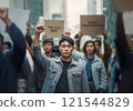 Group of asian people protesting in the street, holding placards and raising fists up. Immigrants riot against inequality and strict laws for refugees 121544829