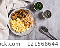 Scrambled eggs, fried chicken and champignons on a plate on the table top view 121568644