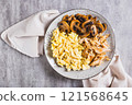 Close up of scrambled eggs, fried chicken and champignons on a plate on the table top view 121568645