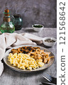 Scrambled eggs, fried chicken and champignons on a plate on the table vertical view 121568642