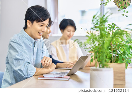 Young male businessman in plain clothes working in the office 121652114