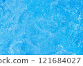 Serene blue water surface with gentle ripples and a soft sun glow 121684027