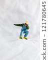 Miniature people  snowboarder dressed in vibrant winter gear, carving through a snowy slope 121780645