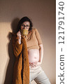 Pregnant woman holding her belly and drinking tea from mug. 121791740