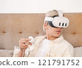 Teenager wearing virtual reality headset at home. 121791752