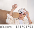 Teenager wearing virtual reality headset at home. 121791753