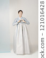 A beautiful woman standing and making a heart shape with her hands wearing an elegant and elegant hanbok 121016428