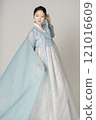 A beautiful woman wearing a luxurious and elegant Hanbok dancing with a blue cloth wrapped around her. 121016609