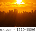 Manila city skyline glowing in warm golden hour sunlight, casting a captivating silhouette against a backdrop of vibrant orange clouds during sunset 121046896