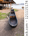 A handcrafted dugout canoe displayed near a lakeside workshop, showcasing traditional wooden craftsmanship 121115174