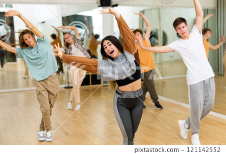 Group of teenagers rehearsing contemporary dance indoors 121142552