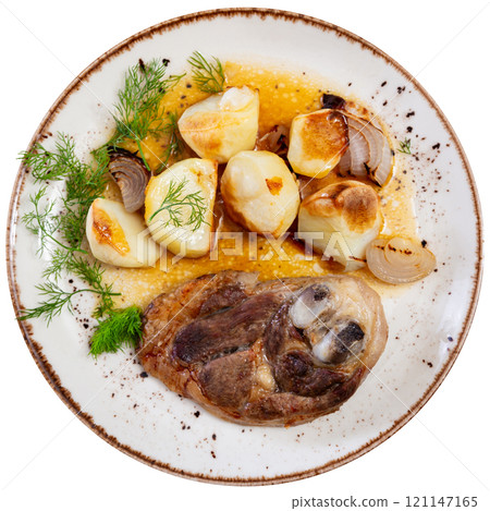 Appetizing lamb leg with baked potatoes and pepper, served on platter with onion 121147165