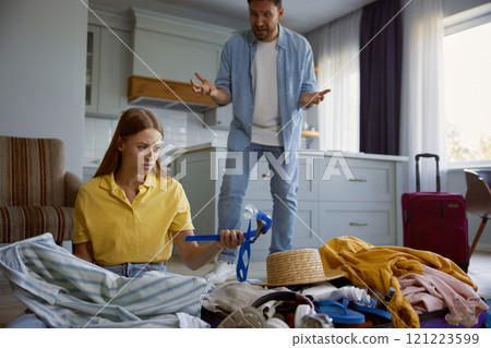 Couple quarreling because of clothing excess prepared for vacation 121223599