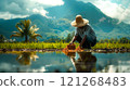 A man in a straw hat is working in a rice field 121268483