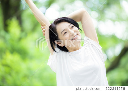 Middle-aged woman stretching in the park 122811256