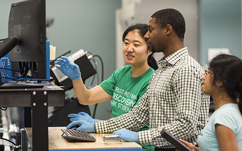 Three graduate students working in lab