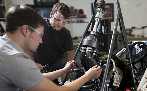 Two students working on a race car frame