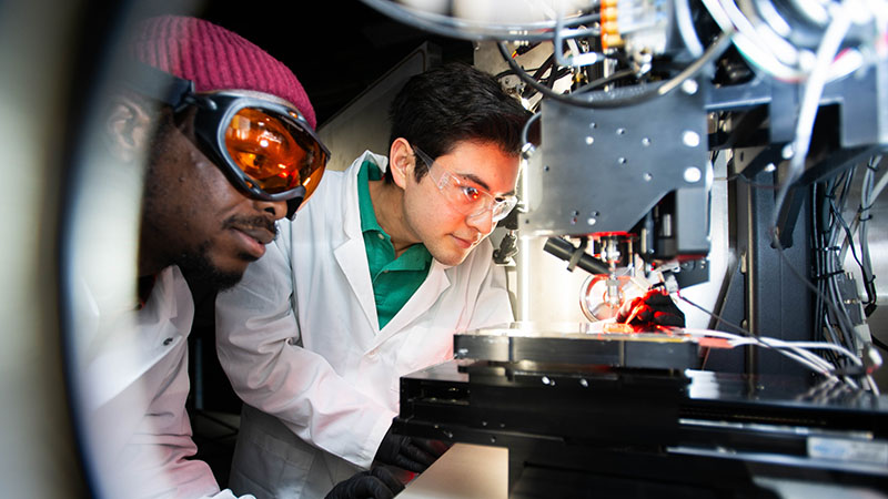 Two researchers wearing goggle work in CMEE lab