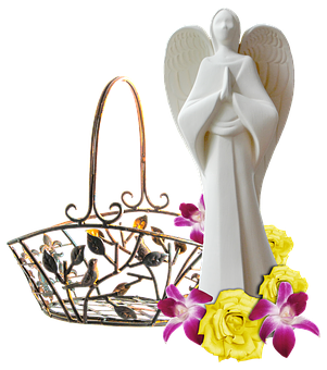 A White Angel Statue Next To A Basket With Flowers