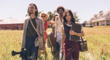 A group of filmmakers walking in a yellow field