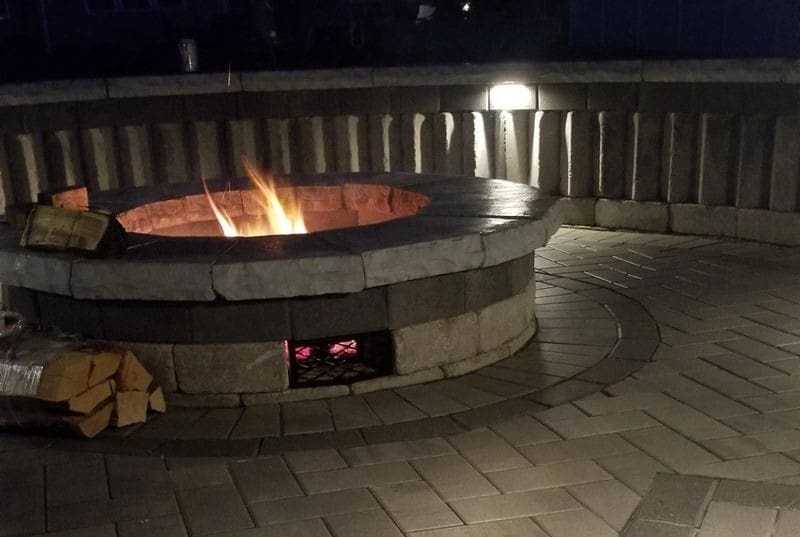 A fire pit with lights on the side of it.