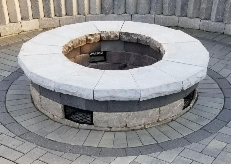 A fire pit with brick walls and stone surround.