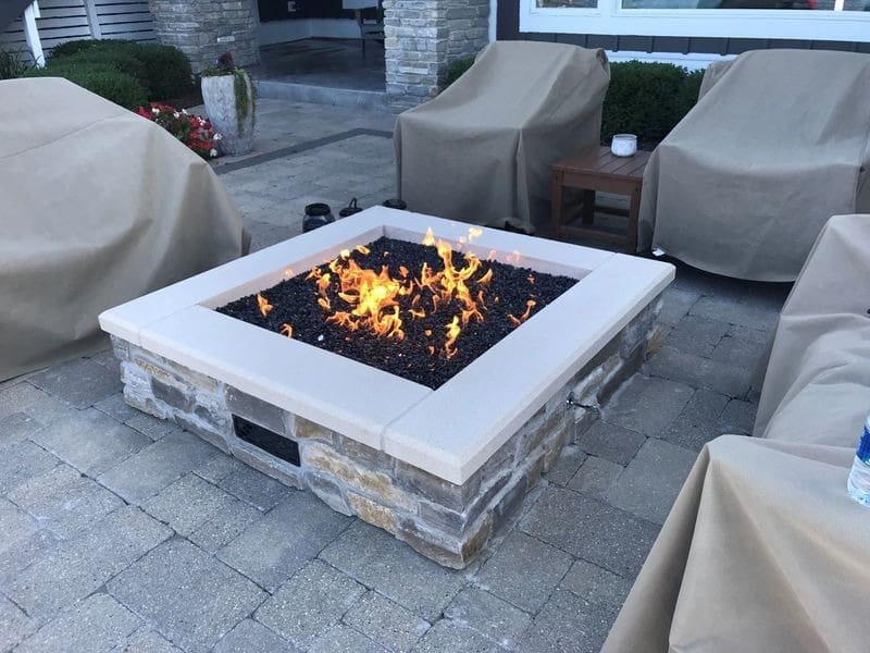 A fire pit sitting on top of a brick patio.