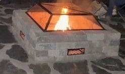 A fire pit with a lit up fire inside of it.