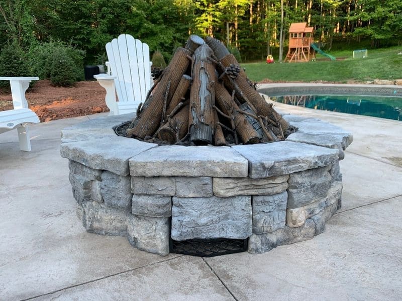 A fire pit with wood burning in it.