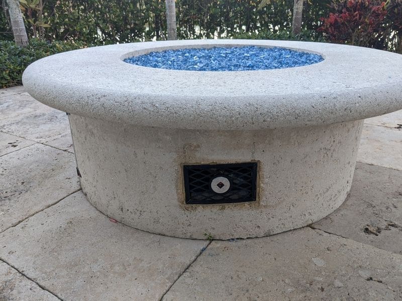 A fire pit with blue stones on top of it.