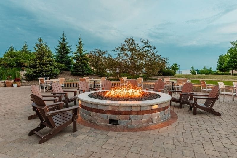 A fire pit surrounded by wooden lawn chairs.