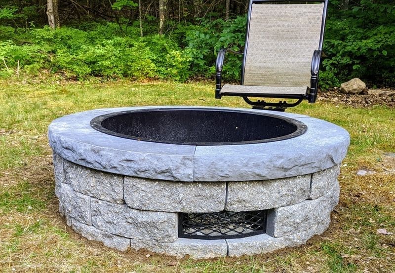 A fire pit with a chair in the middle of it