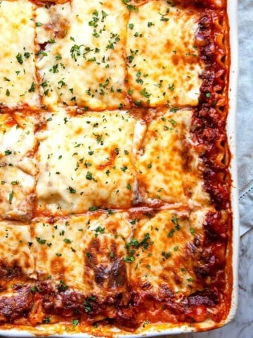 Classic Lasagna - layers of silky smooth, creamy parmesan béchamel sauce, a slow simmered Bolognese meat sauce, sheets of pasta, and lots of mozzarella cheese make this the World’s Best Lasagna recipe.