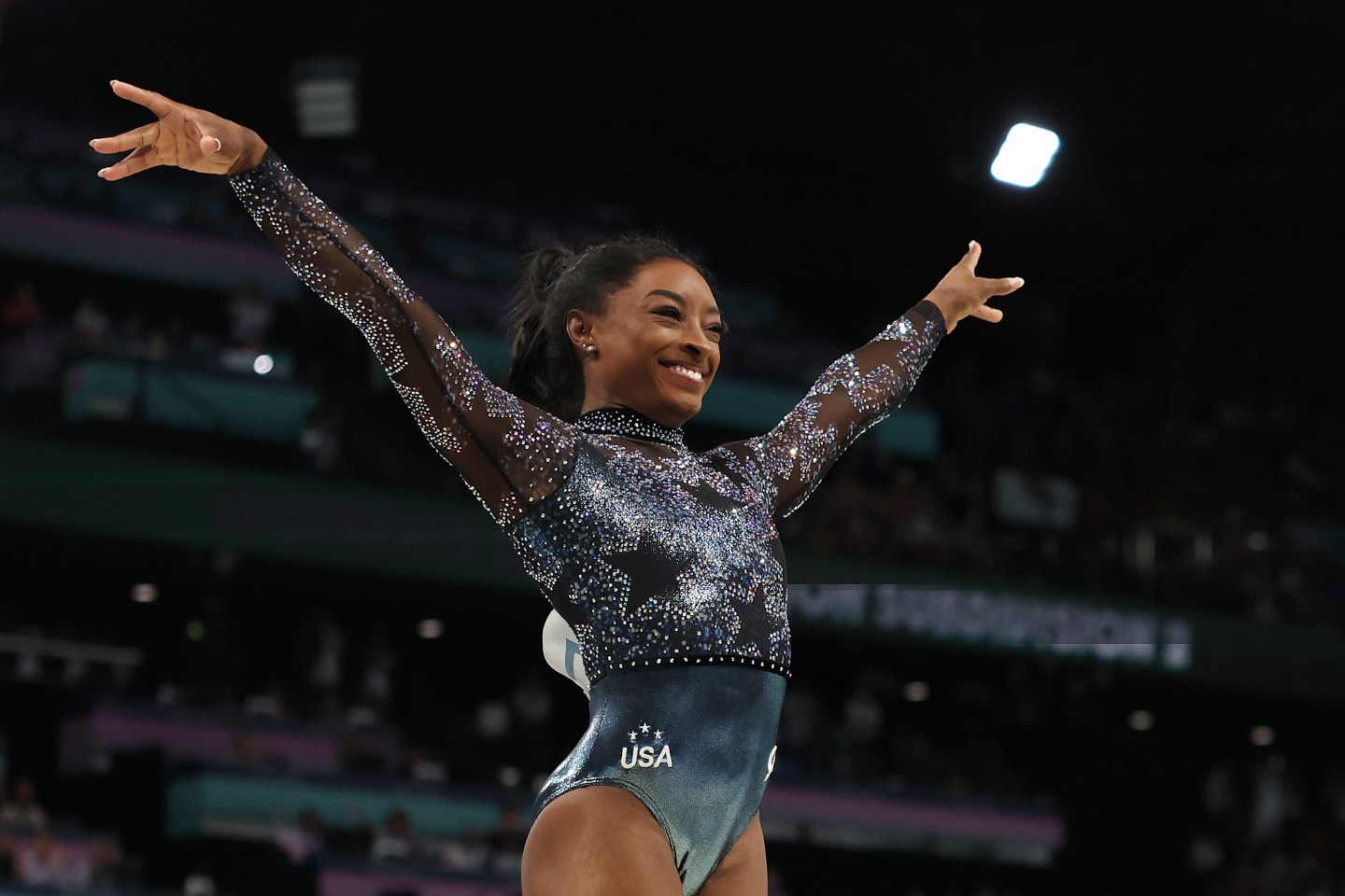 Simone Biles in a black leotard with a sparkly star pattern