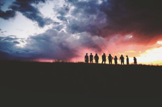 People standing in front of sunset.