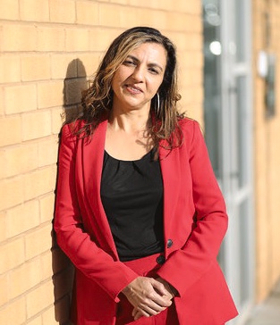 A headshot image of Monica Shafaq smiling towards the camera.