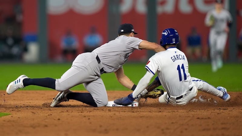 Kansas City Royals' Maikel Garcia, right, is tagged out at second by New York Yankees...