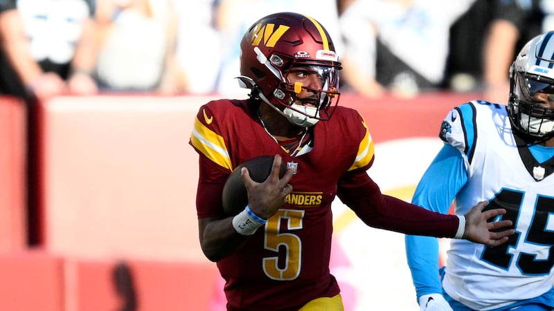 Washington Commanders quarterback Jayden Daniels (5) runs from Carolina Panthers safety Nick...