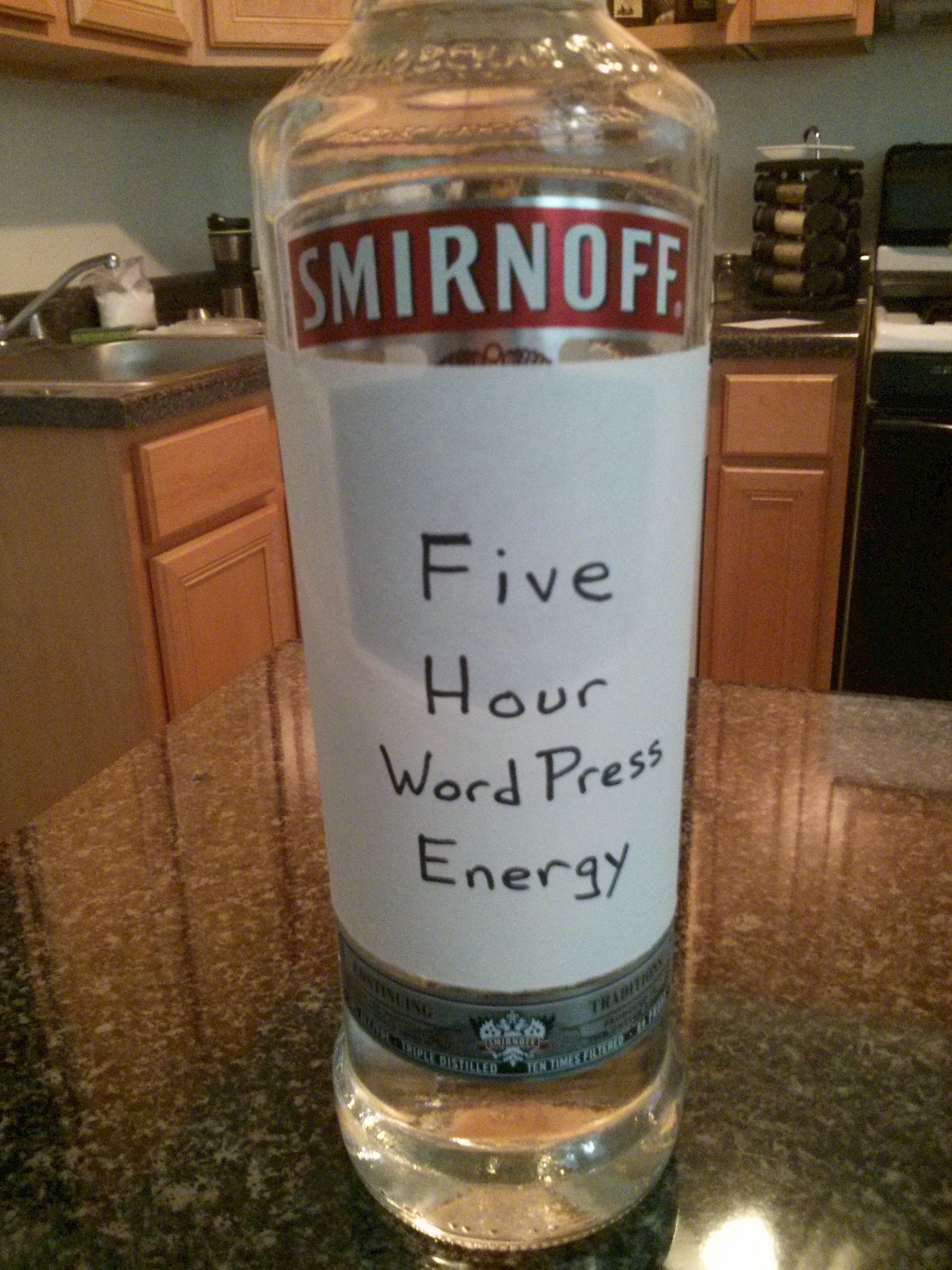 Close up of a bottle of Smirnoff vodka with a hand-written label covering it, 