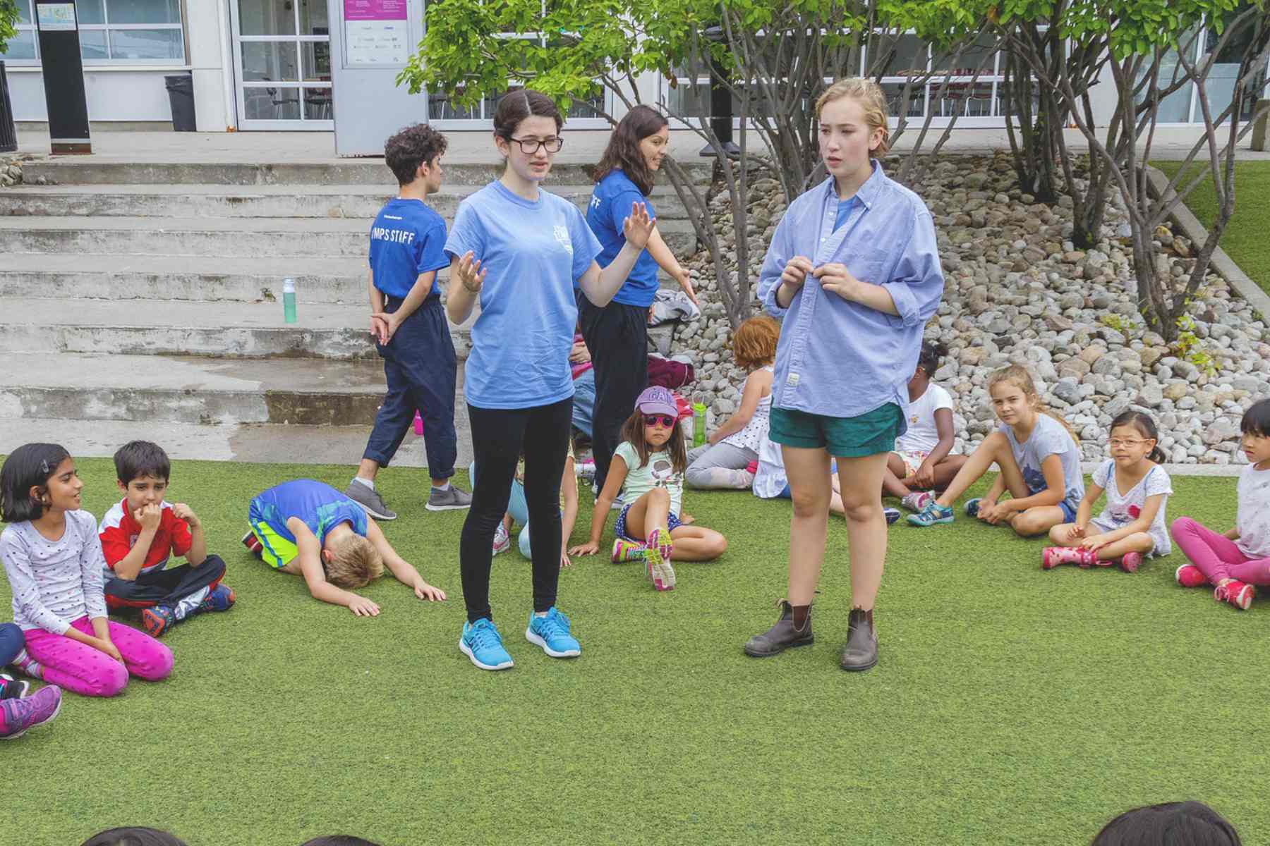 A circle of campers listen to their counsellors