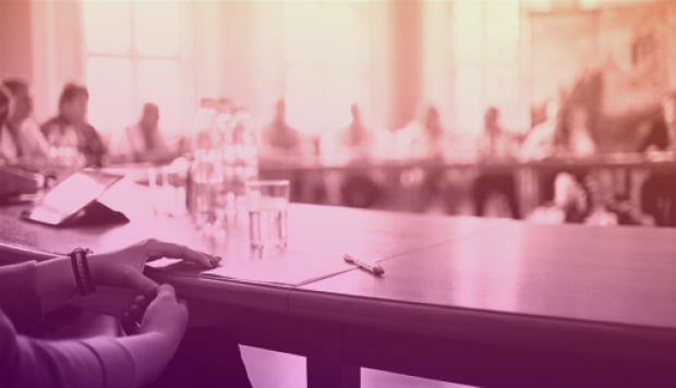 people sitting around a large board room table