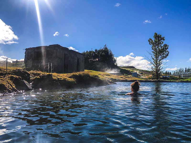  woman swimming in geothermal pool in fludir secret lagoon Iceland