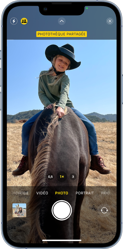 L’écran Appareil photo est ouvert et un sujet remplit le cadre. En haut de l’écran Appareil photo, le bouton « Photothèque partagée » est activé.