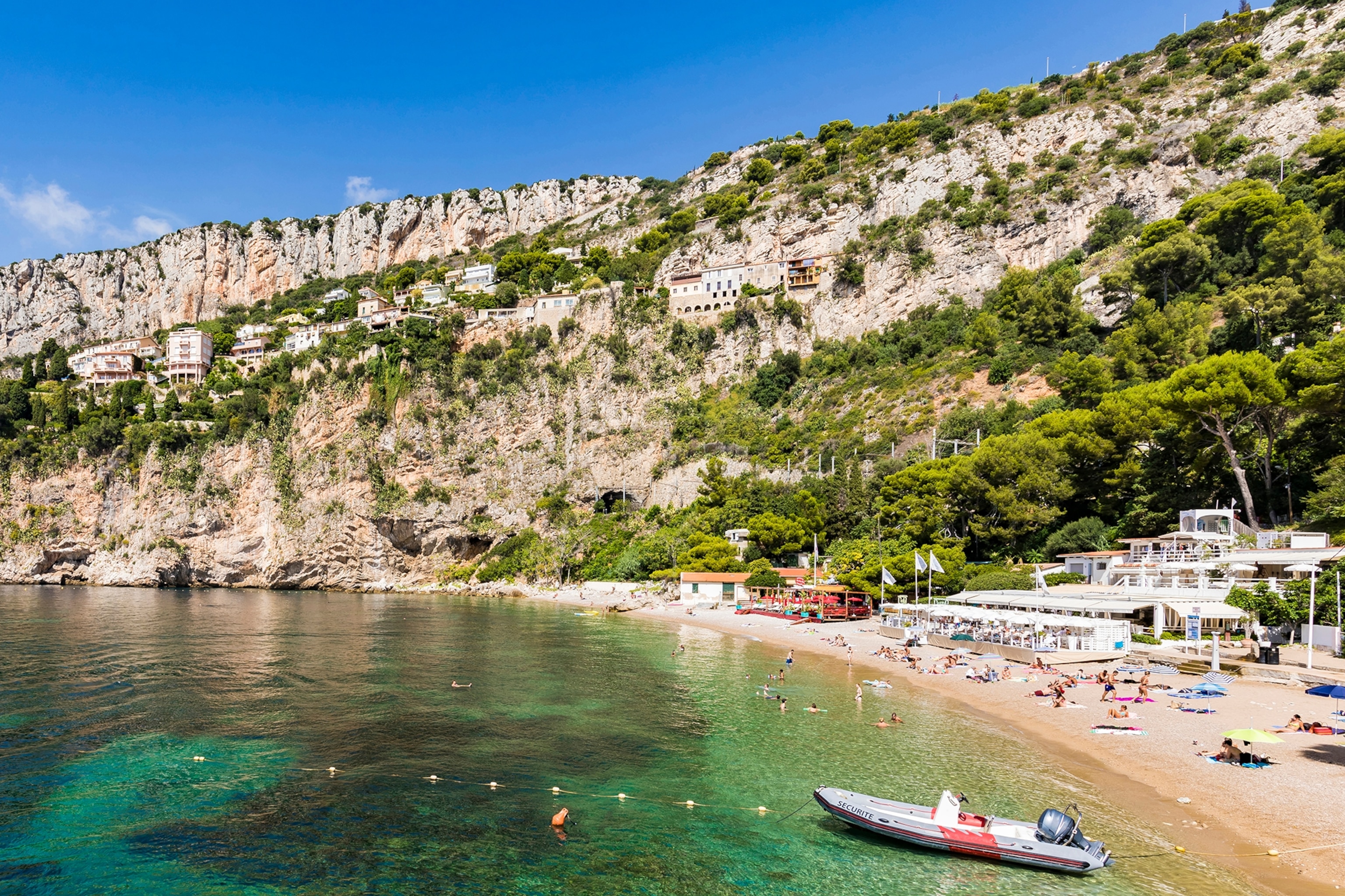 Beach with turquoise waters surrounded by rocky cliff faces