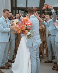 Zach and Brooke's wedding featured a harmonious color palette of soft and vibrant tones. The bridal accessories showcased a delicate combination of white and light blue, highlighted by intricate blue floral embroidery on the shoes and a small bouquet of pale blue flowers. The ceremony setup maintained a clean and elegant look with rows of white chairs. The newlyweds and their wedding party added pops of color, with the groom and groomsmen in light blue suits and the bride holding a vibrant bouquet of mixed flowers, creating a beautiful blend of white, blue, and lively floral hues