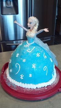 Elsa doll cake I used the Wilton Doll cake pan and doubled a cake recipe. Baked for a LONG time. Added a 9" round cake on bottom to allow for the Elsa doll. Used the Wilton Fondant recipe. Found blue and white sparkle sprinkles in the cake decorating aisle of joanns. Used royal icing for the white on the outside.