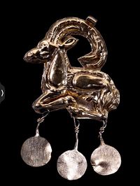 Gold pendant in the form of a Cretan wild goat, with three suspended discs. The pendant is made of sheet gold and has a loop for suspension on top of the goat’s horns. Minoan