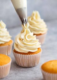 Piping Fluffy Vanilla Frosting onto Vanilla Cupcakes