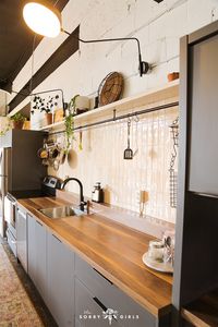 We made this empty industrial garage into the office of our dreams, including this custom DIY kitchen makeover. We learned to tiled vertical organic beige subway tile backsplash all by ourselves, and DIY'd a floating shelf and kitchen rail hack used for pot and pan storage. By adding DIY hanging basket storage, hanging pendant lights, bar bistro tables, and matte black arm wall sconces, we gave our kitchen the mid century modern upgrade we were dreaming of! Click for more kitchen inspo!